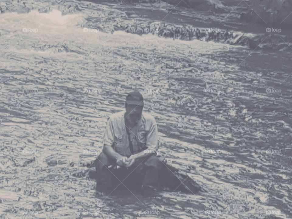 black & white of man relaxing in the river fishing