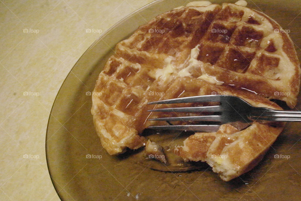 Eating a waffle with butter and syrup 
