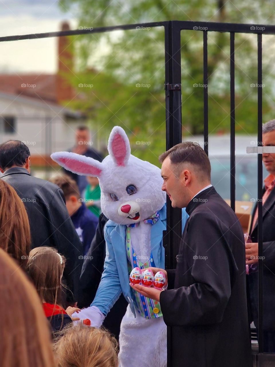 Easter bunny giving eggs to children