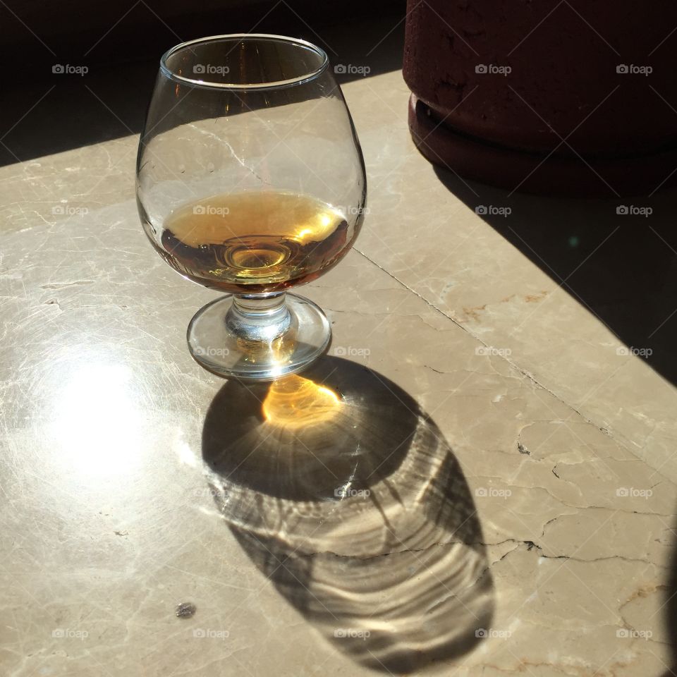 Cognac in a glass on a marble table.