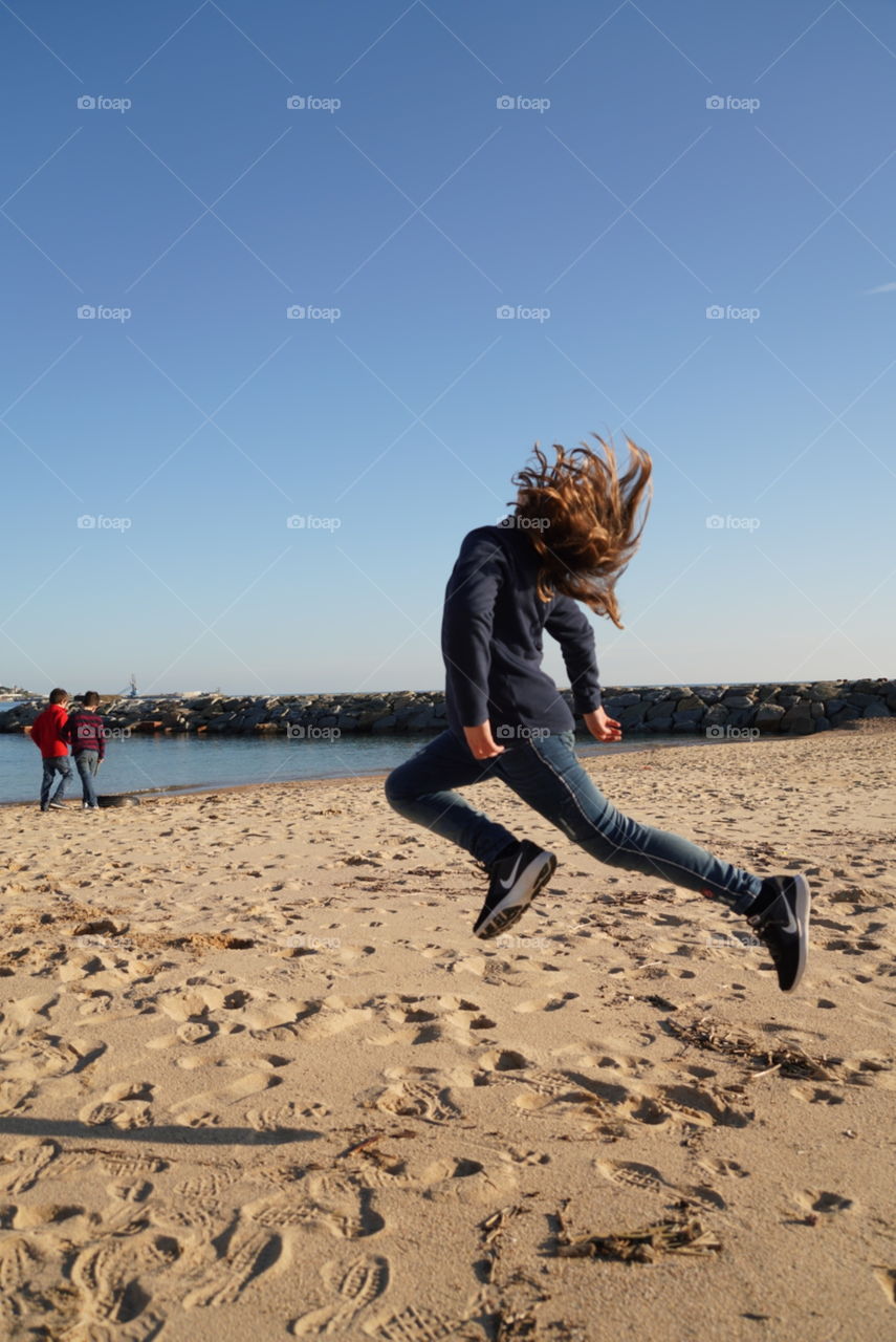 niña salto playa