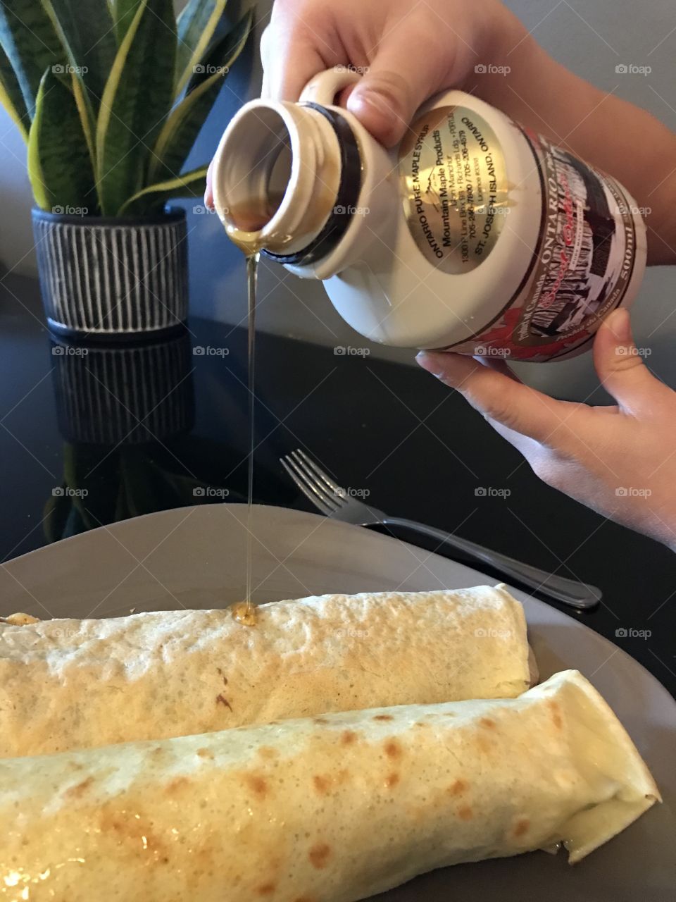 Pouring maple syrup on to crepes