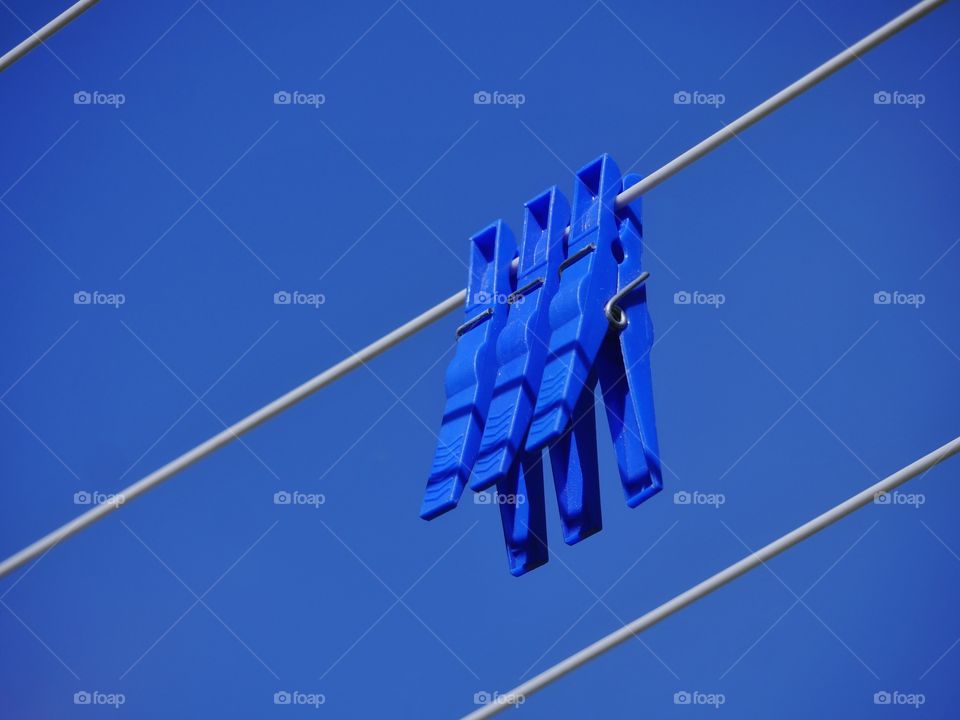 Blue clothespins against blue sky