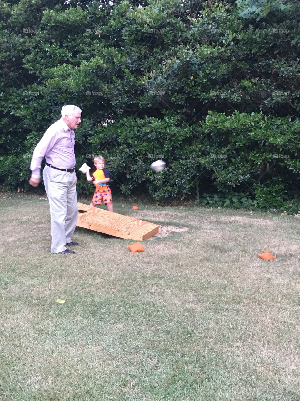 Boy playing in garden with his grandfather
