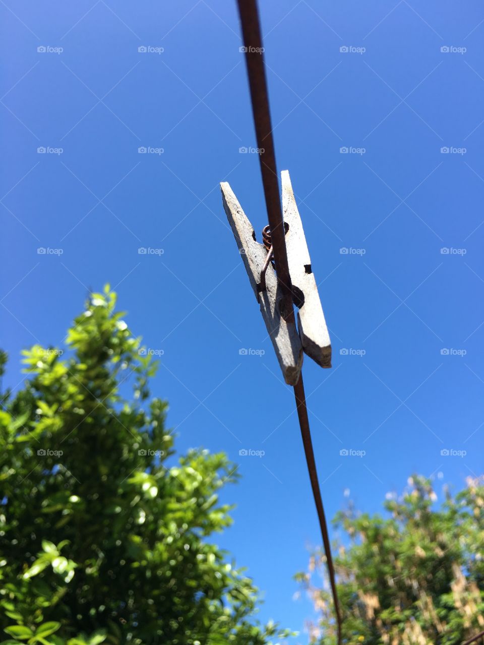 Wood clothespin clothes peg on clothesline outdoors blue sky background