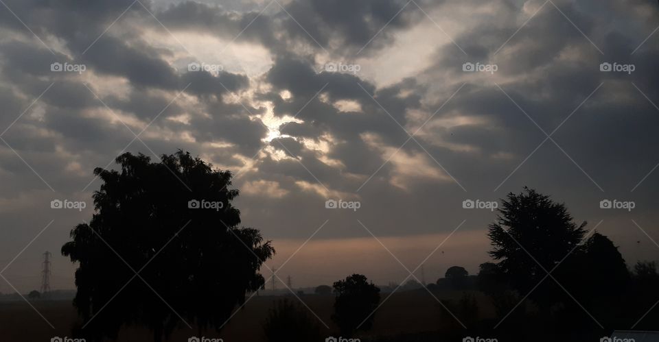 at sunrise, one crazy sky is formed, grey clouds spread and reform coving the sun, seeming in such a sister way.