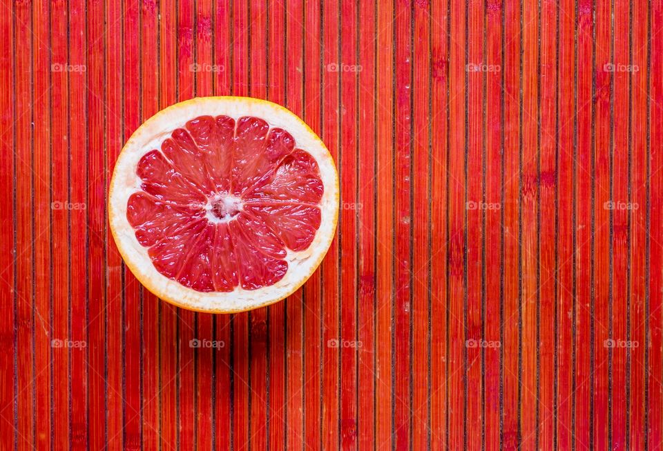 Grapefruit half on red background