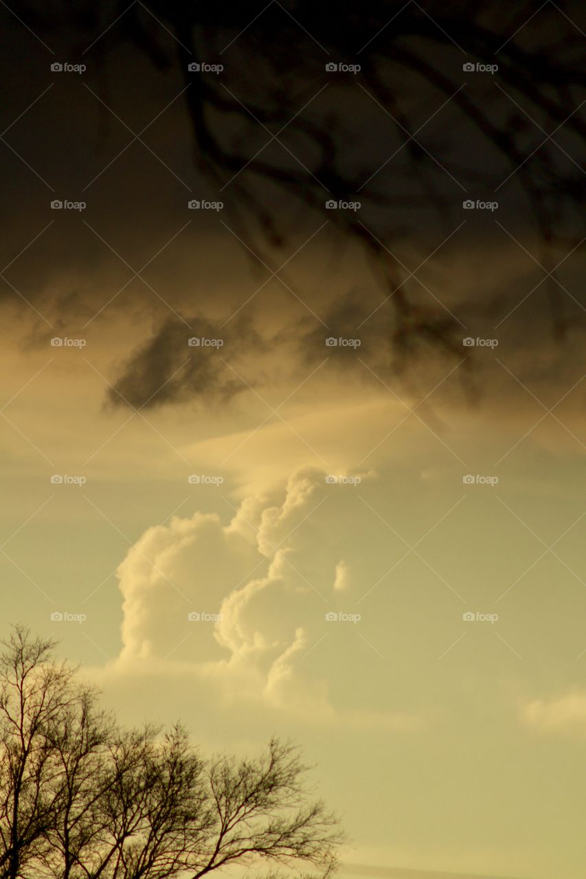 Towering white clouds in a clearing sky in the distance and a dark dramatic sky after a storm in the foreground