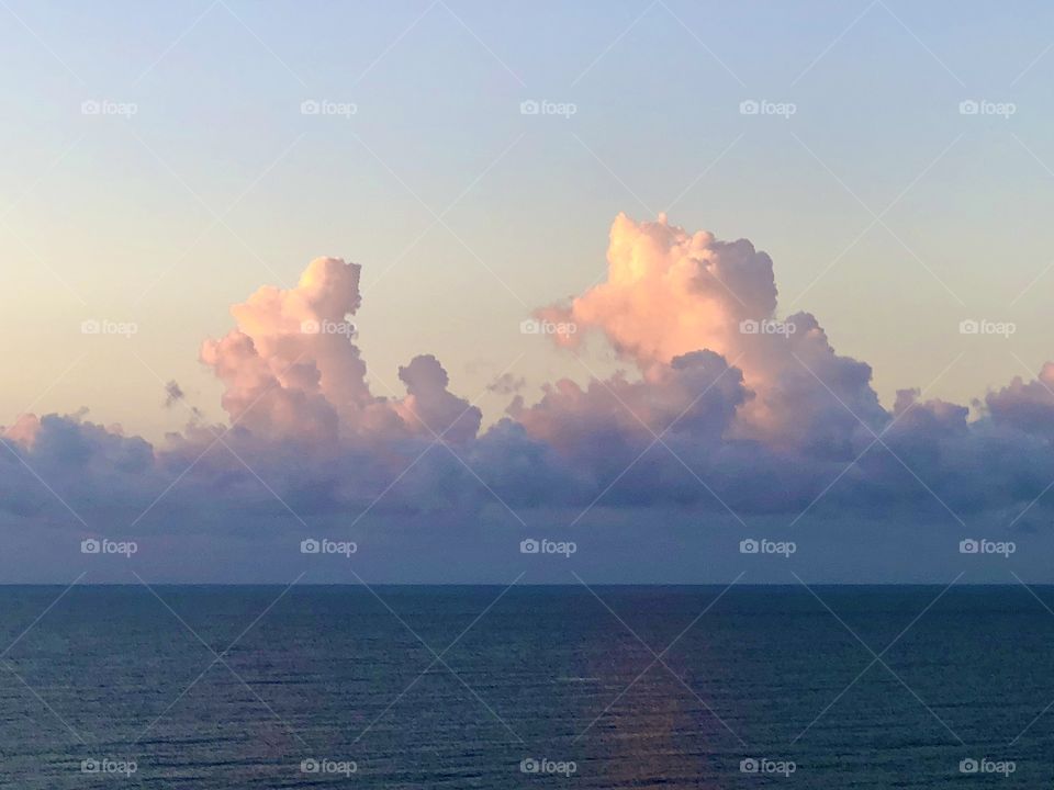 Sunlight on clouds and reflection on ocean