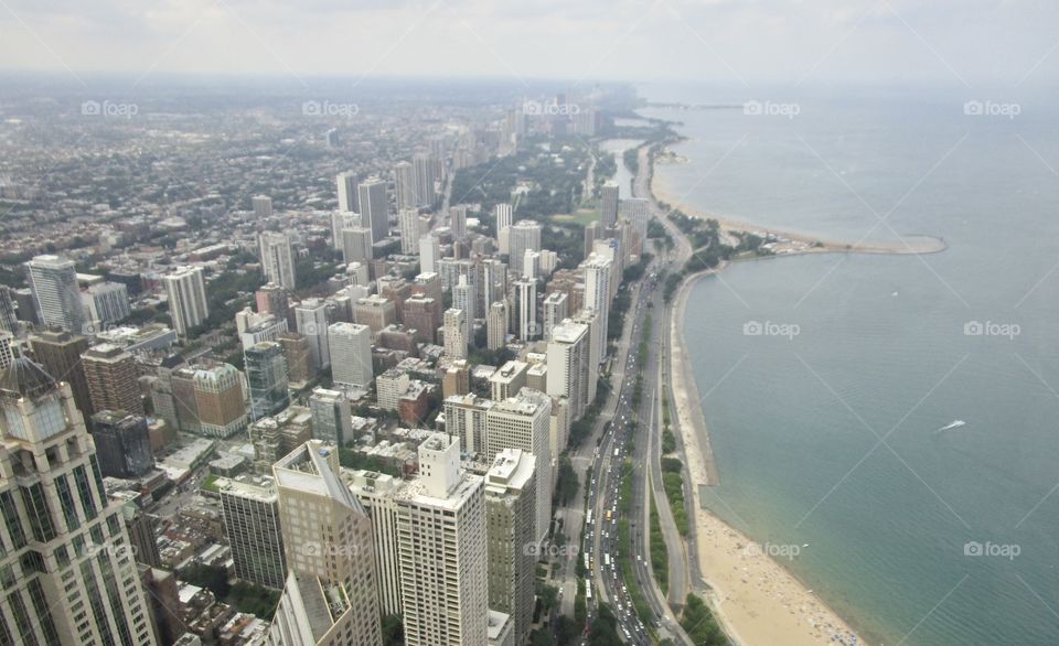 An aerial view of city buildings along the shore of Lake Michigan with light fog