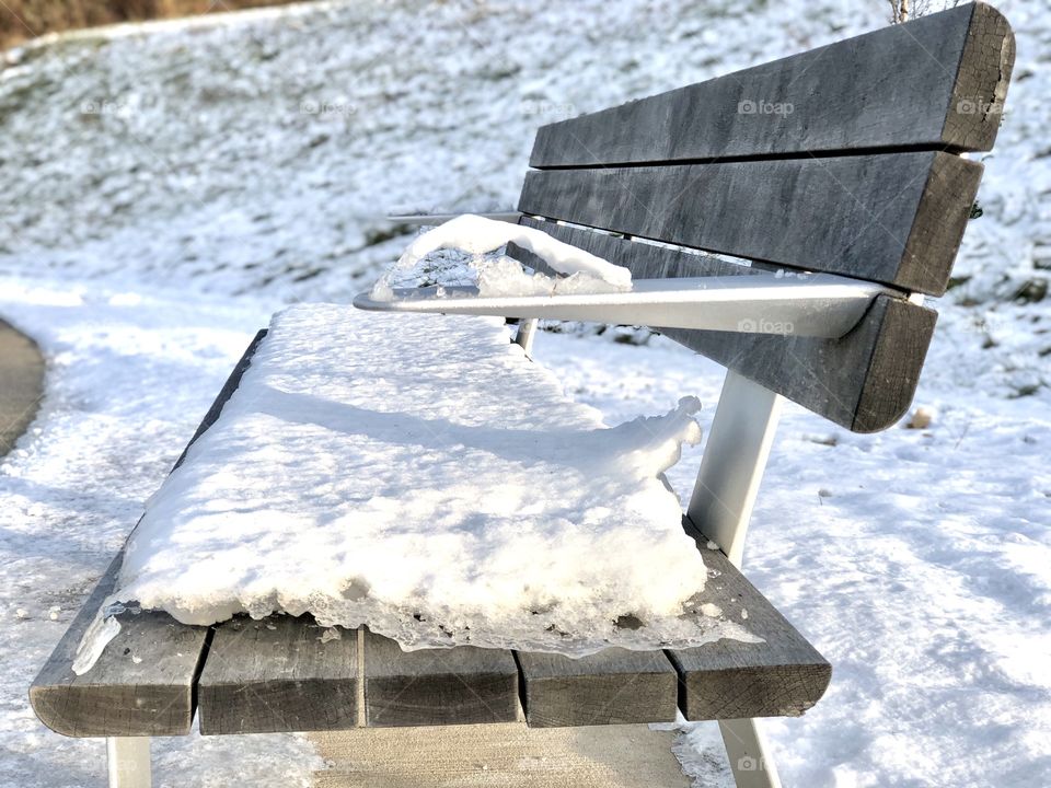 Snow covered park bench