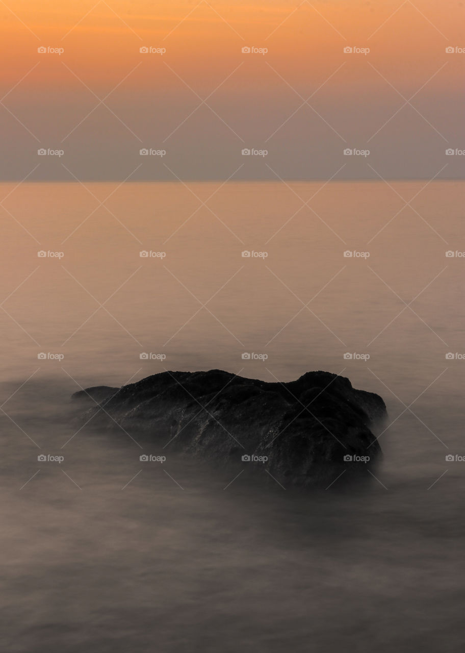 Black Color Beach Rock during Sunrise Dawn.