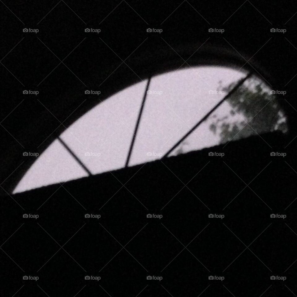 Nighttime, laying in bed looking up at window during thunderstorms 