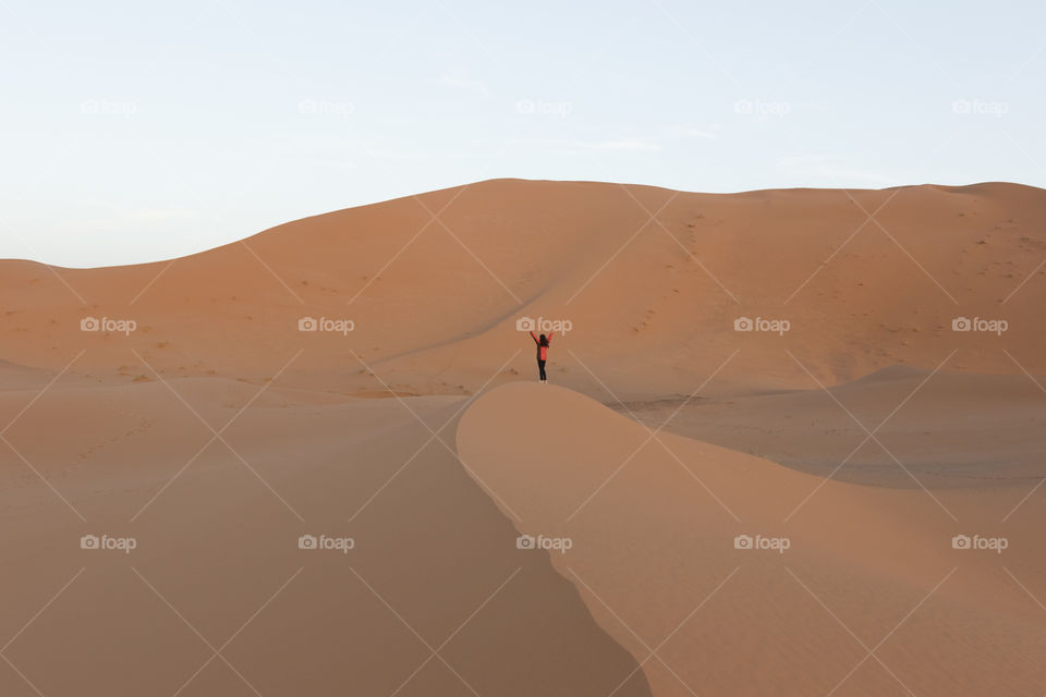 Lonely female standing in sand