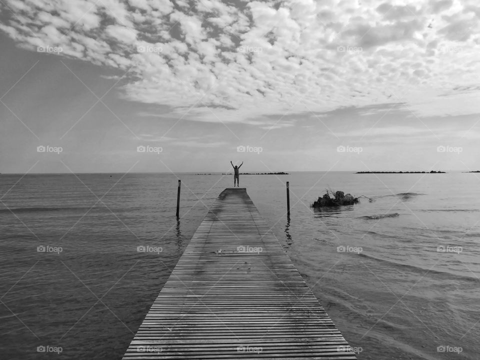 Man in the distance jumps on the pier