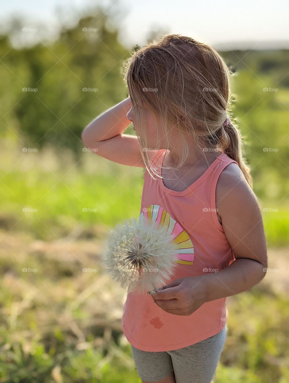 blonde girl holding giant dandelion