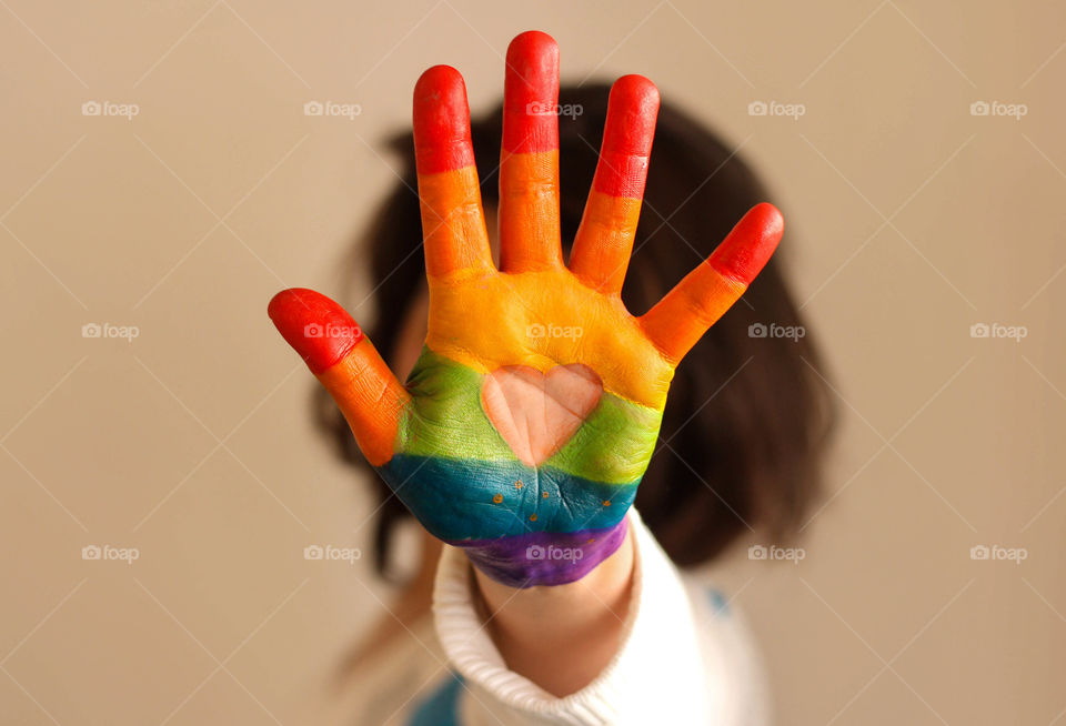 Painted rainbow colors on a palm and a heart
