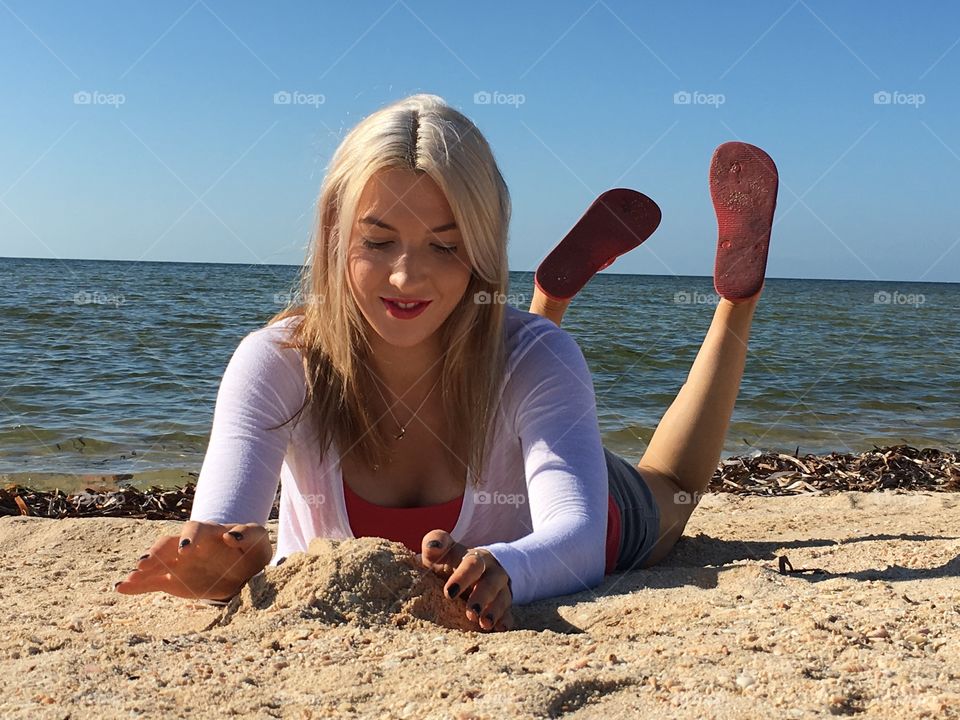 Woman lying on sand at beach