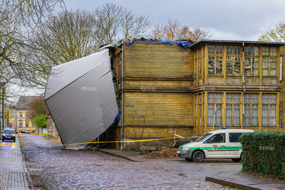 yellow police tape surrounds this building following a severe storm that lifted and removed a metal roof, storm damage