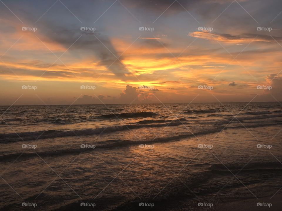 Small waves during peaceful orange sunset