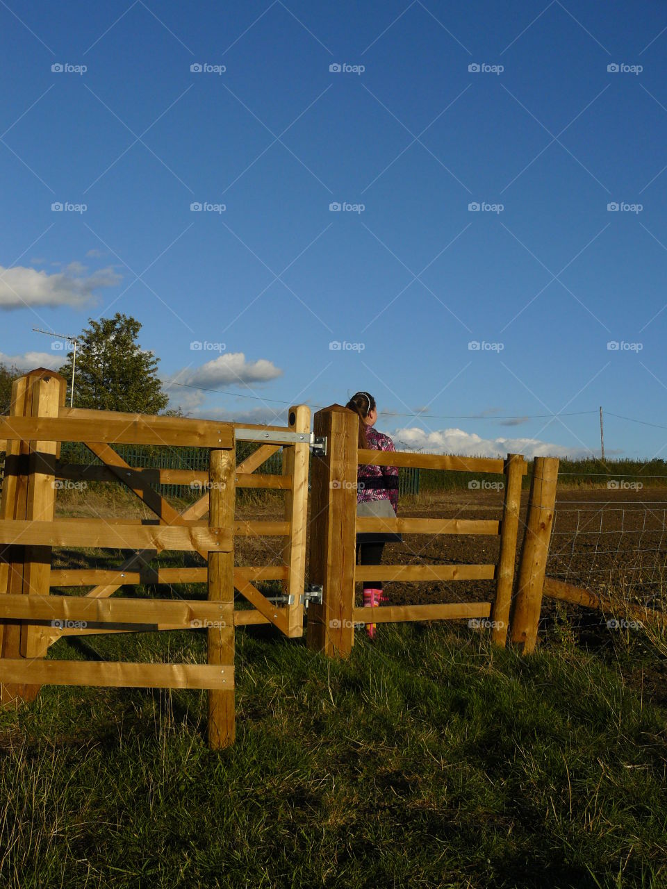 Wooden Fence And Gate On A Public Footpath Through A Farmers Field - Blue Sky With Clouds - Girl Looking Into The Distance