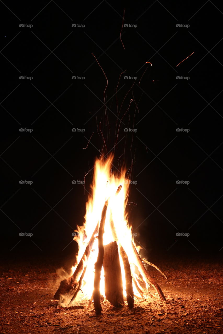 Around a warm campfire at night.