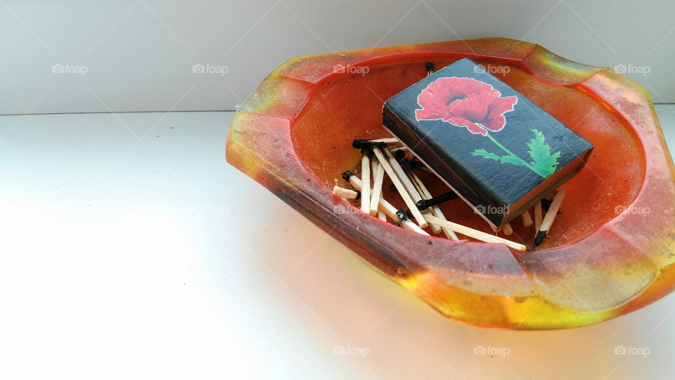 a box of matches lies in an ashtray