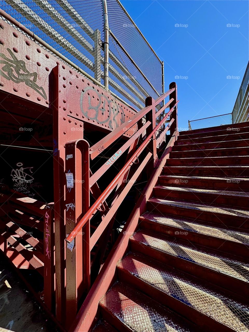 The very “Bauhaus” red metal stairs of the “Pulaski Bridge” at “Newtown Creek” in “Greenpoint”, Bklyn have heavily bolted metal support structures and other industrial elements, they remind of a 1930s “Max Ernst” painting. 2024. Hypnotic Productions