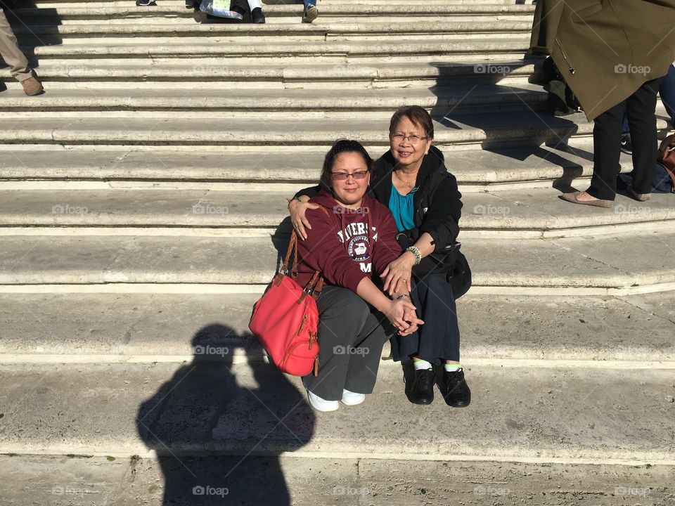 Two asian woman sitting on steps