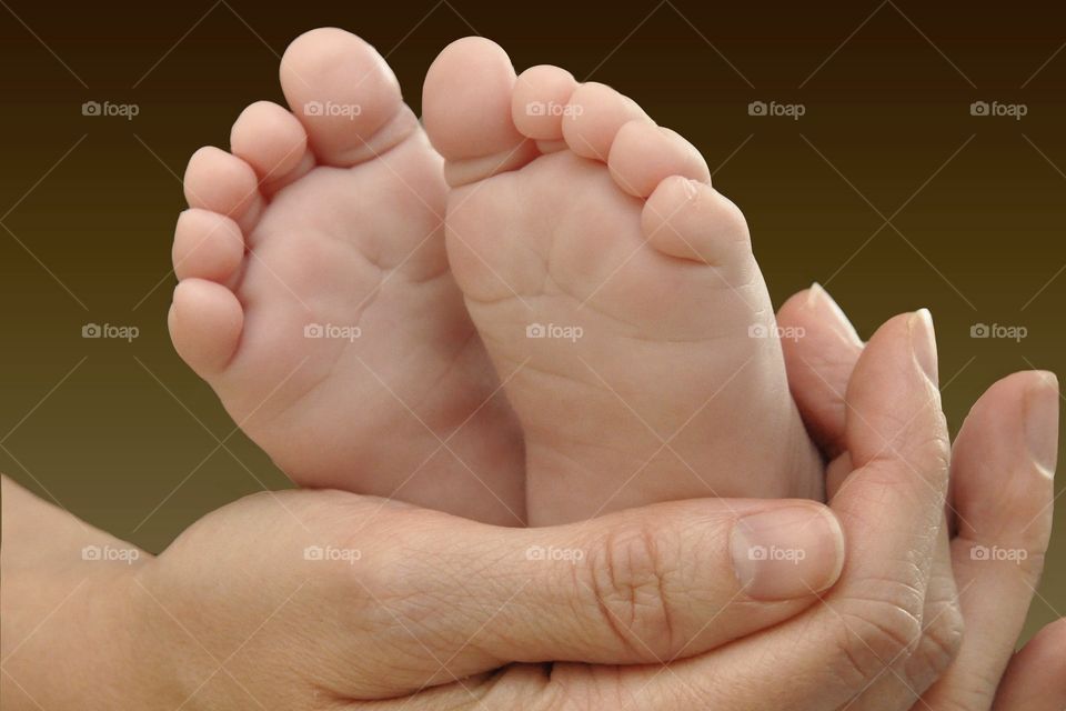 Mom holding baby’s feet in her hands