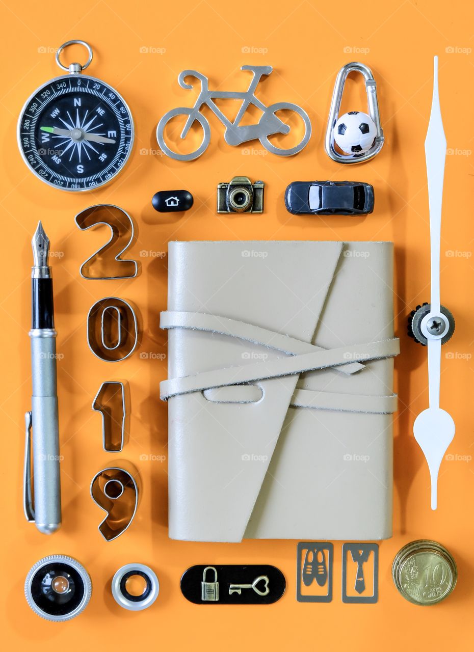 Flat lay of notebook and stationary on orange background 