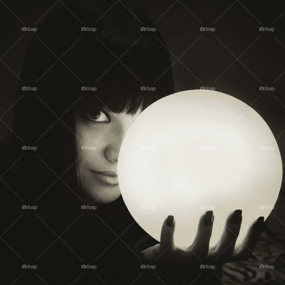 Close-up of a woman holding illuminated sphere