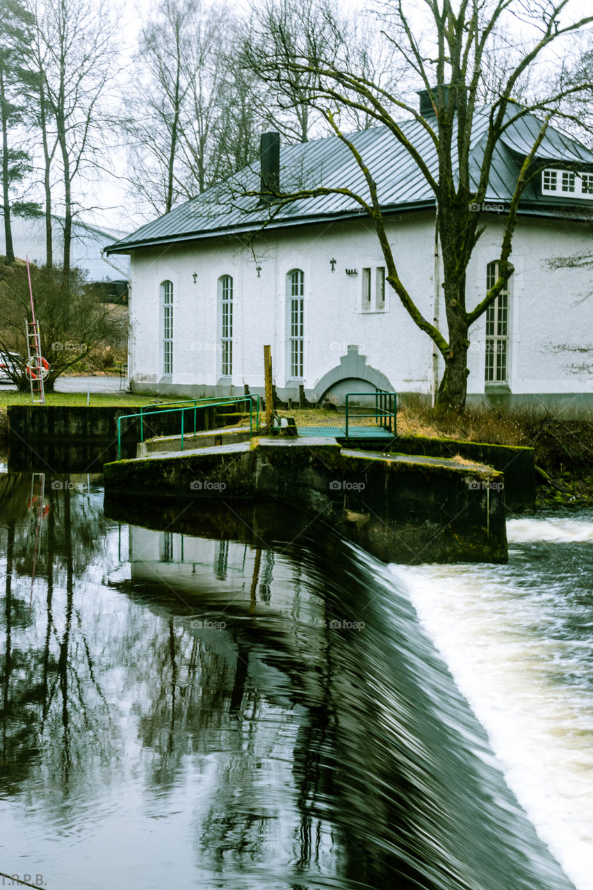 old mill house reflecting on the river that powers the work done inside