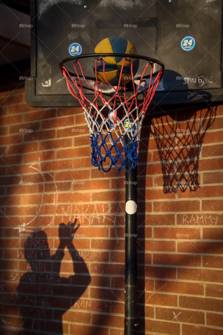 Teenager is practicing basketball shots