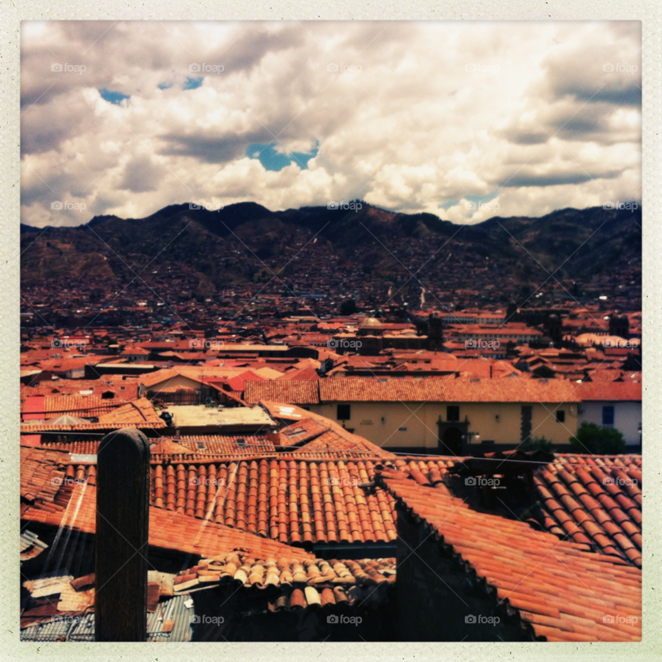 sky clouds rooftops mountains by MegTStewart
