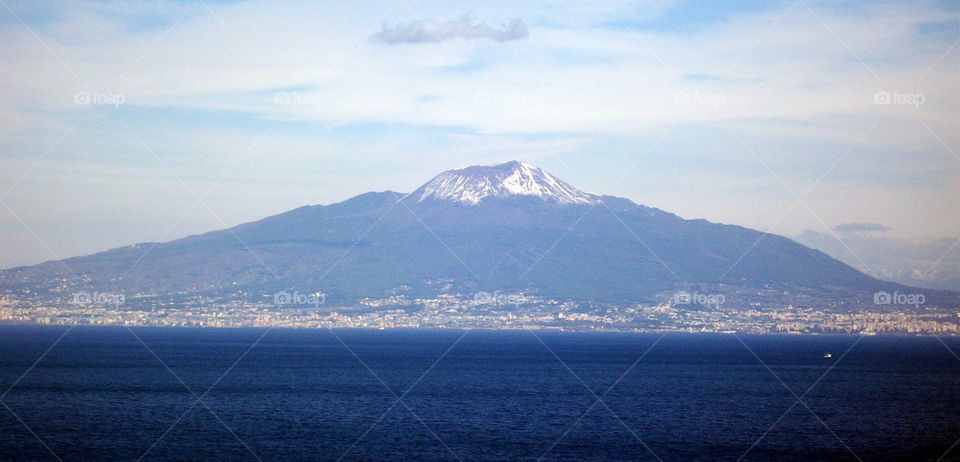 A calm photo of Mount Vesuvius and the city below from across the water on this bright spring day