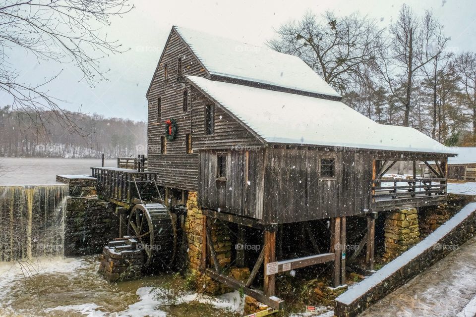 Foap, Signs of Winter: The ole gristmill with a holiday wreath in a snow storm at Historic Yates Mill County Park in Raleigh North Carolina. 