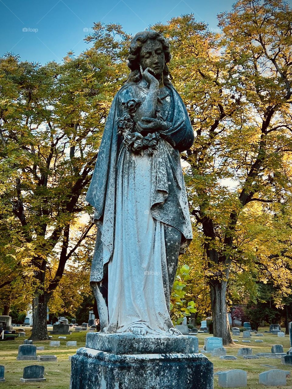 An eerily beautiful gravestone on a chilly autumn evening 