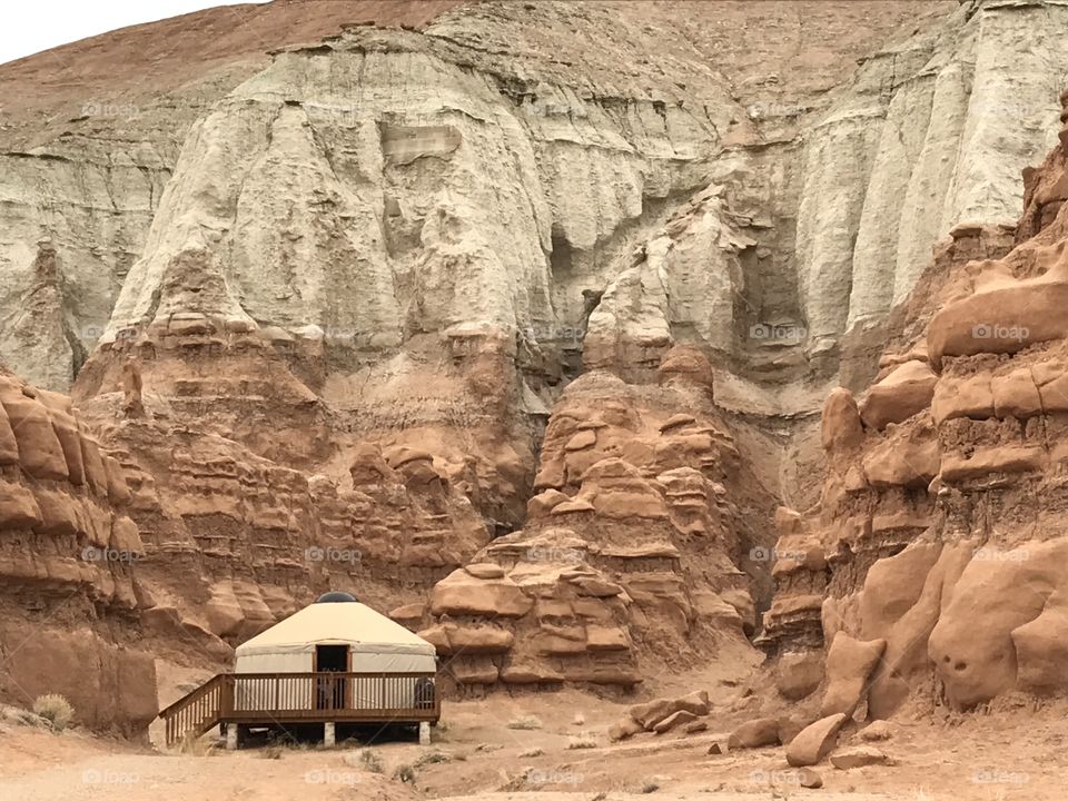 Yurt at the base of a sandstone cliff