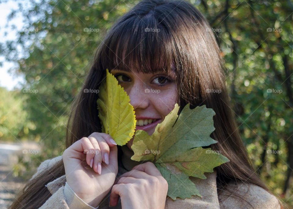 Smiling Young Girl on Autumn Background