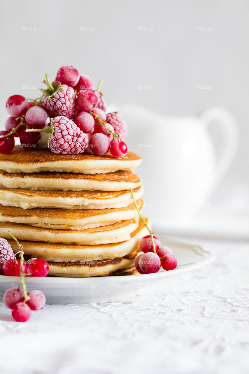 Stack of pancakes with frozen berries