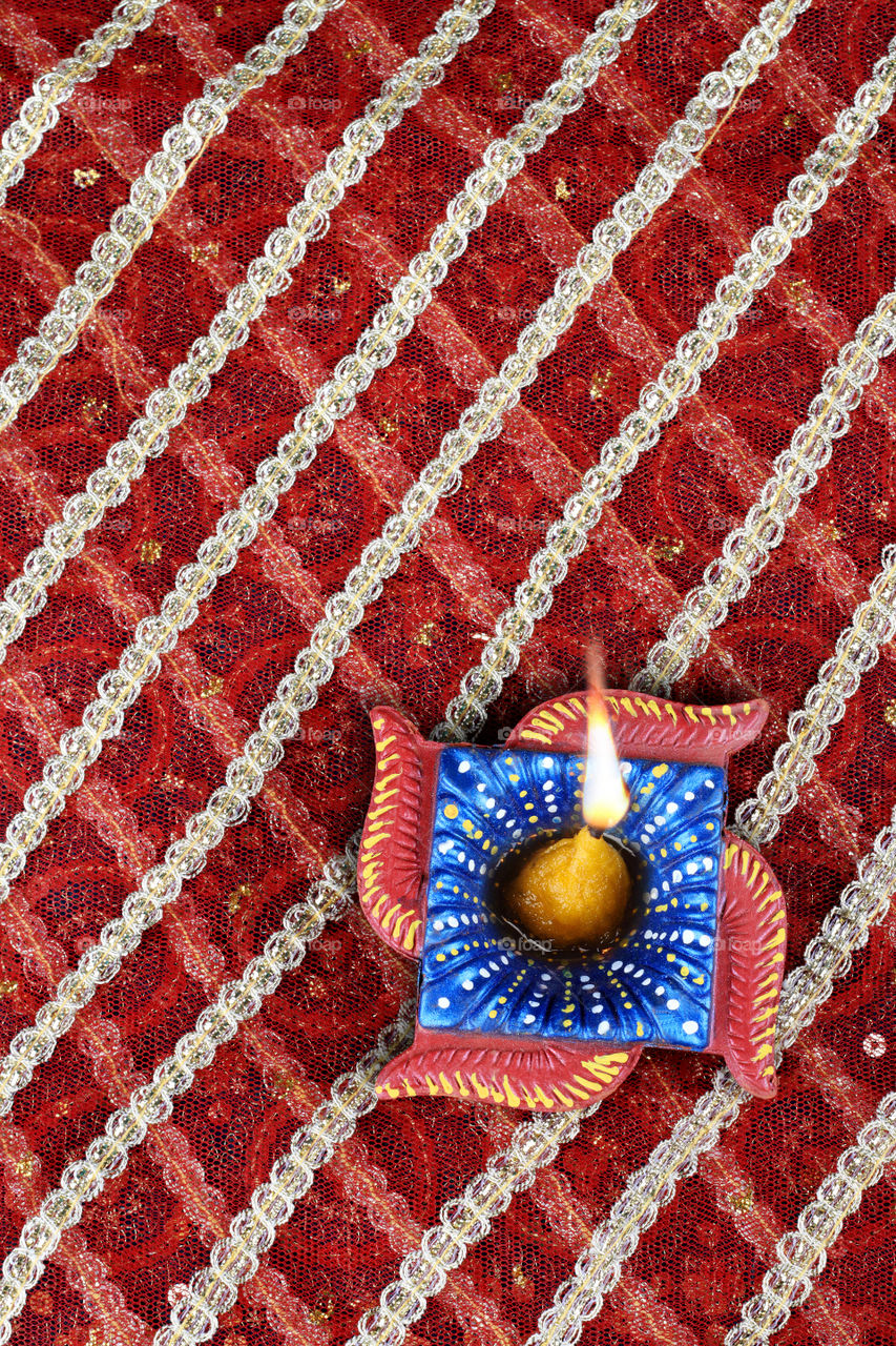 Red and Blue fabric with a diya.