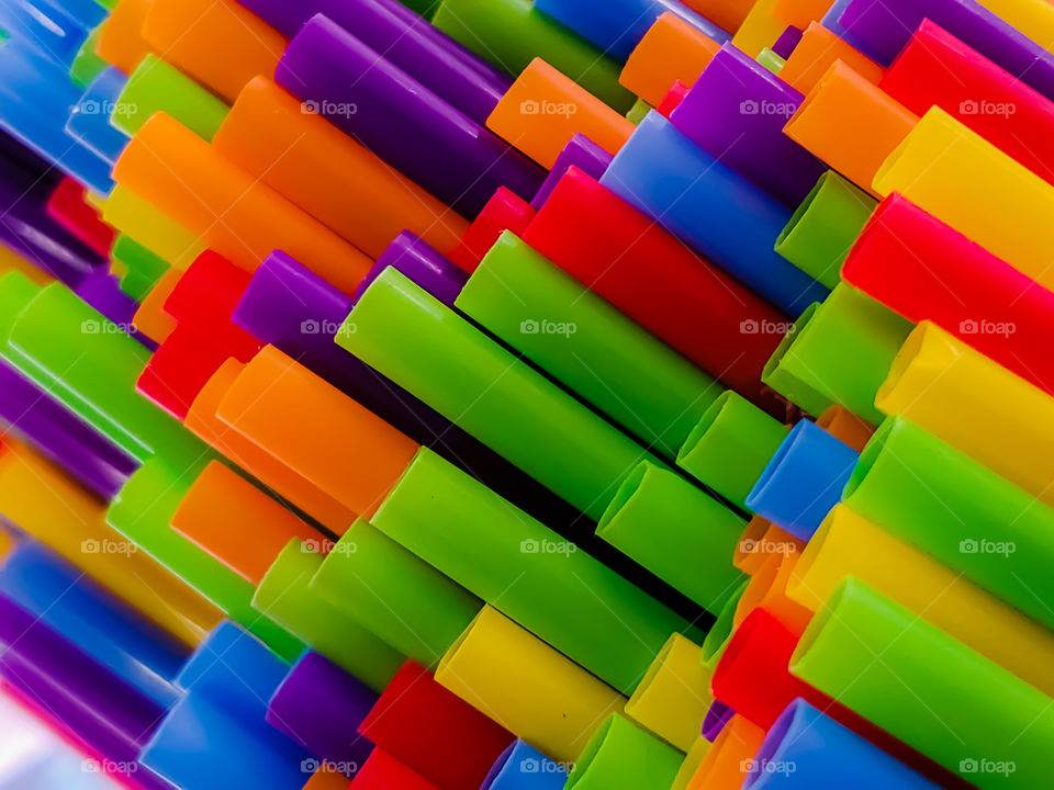 Rainbow colored diagonol straws protruding at different lengths creating an interesting look.