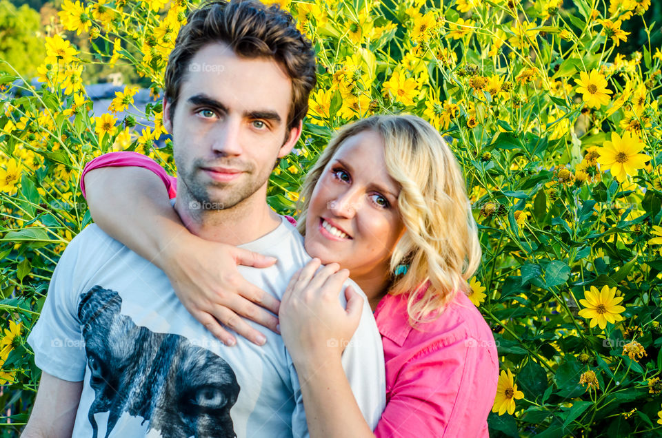 Portrait of couple in field of yellow flowers
