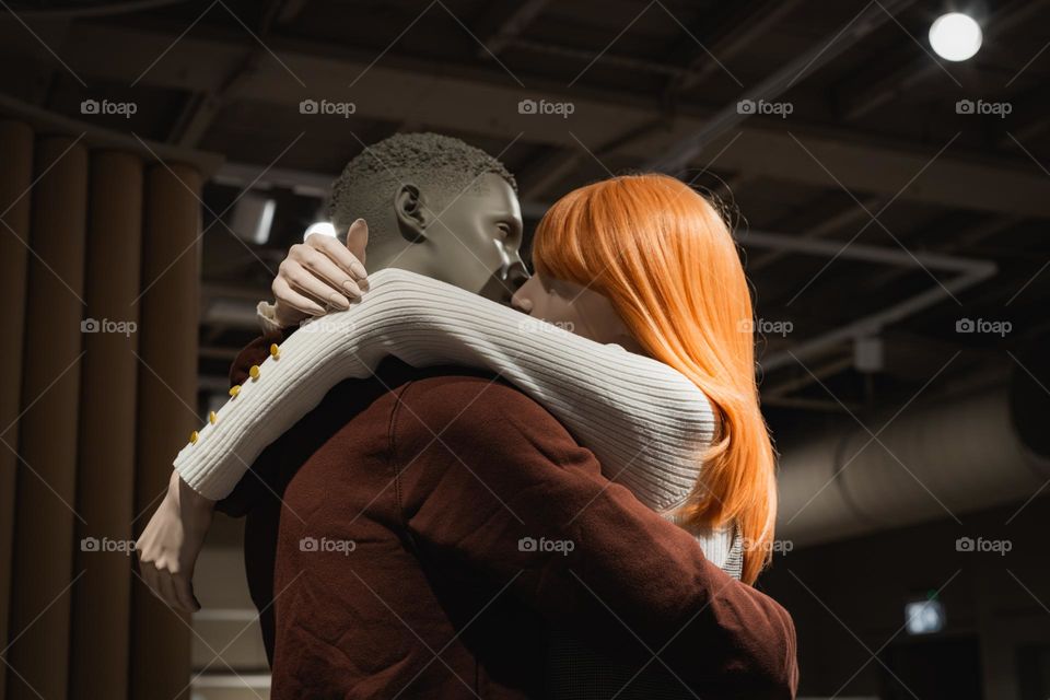 Beautiful portrait of a romantic couple of two mannequins kissing and hugging a guy and a girl on a stand in a store in mastricht holland, close-up side view. The concept of love, a romantic couple.