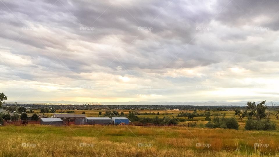 Distant City. Denver skyline drenched in sunlight in the distance along the horizon.