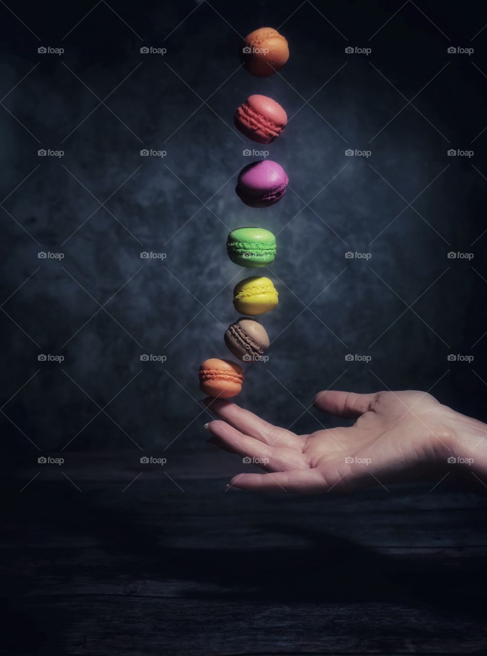 multicolored macaroons falling in hand