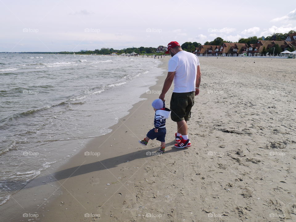 Father and son. It's me walking with my son on the beach in summer time