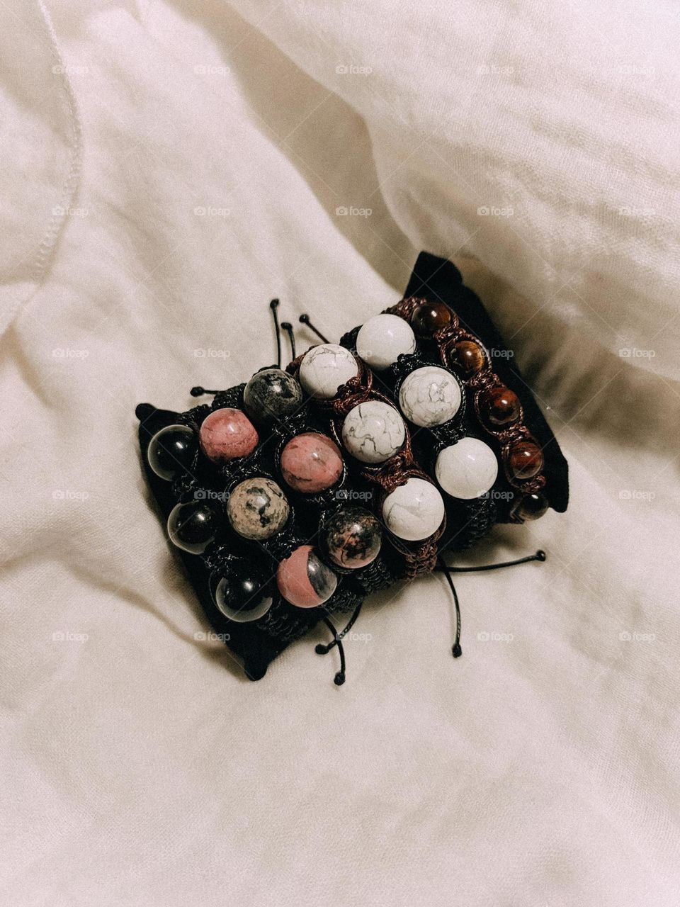 Stone bracelets flatlay on the milk fabric background