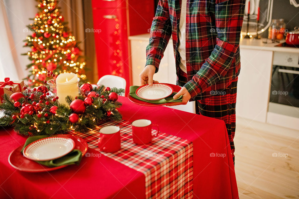 man sets a beautiful decorated winter table for a festive dinner.  Merry Christmas and Happy New Year.